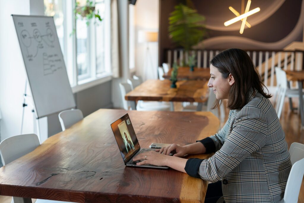 woman participating in live televideo interviews on laptop in an office